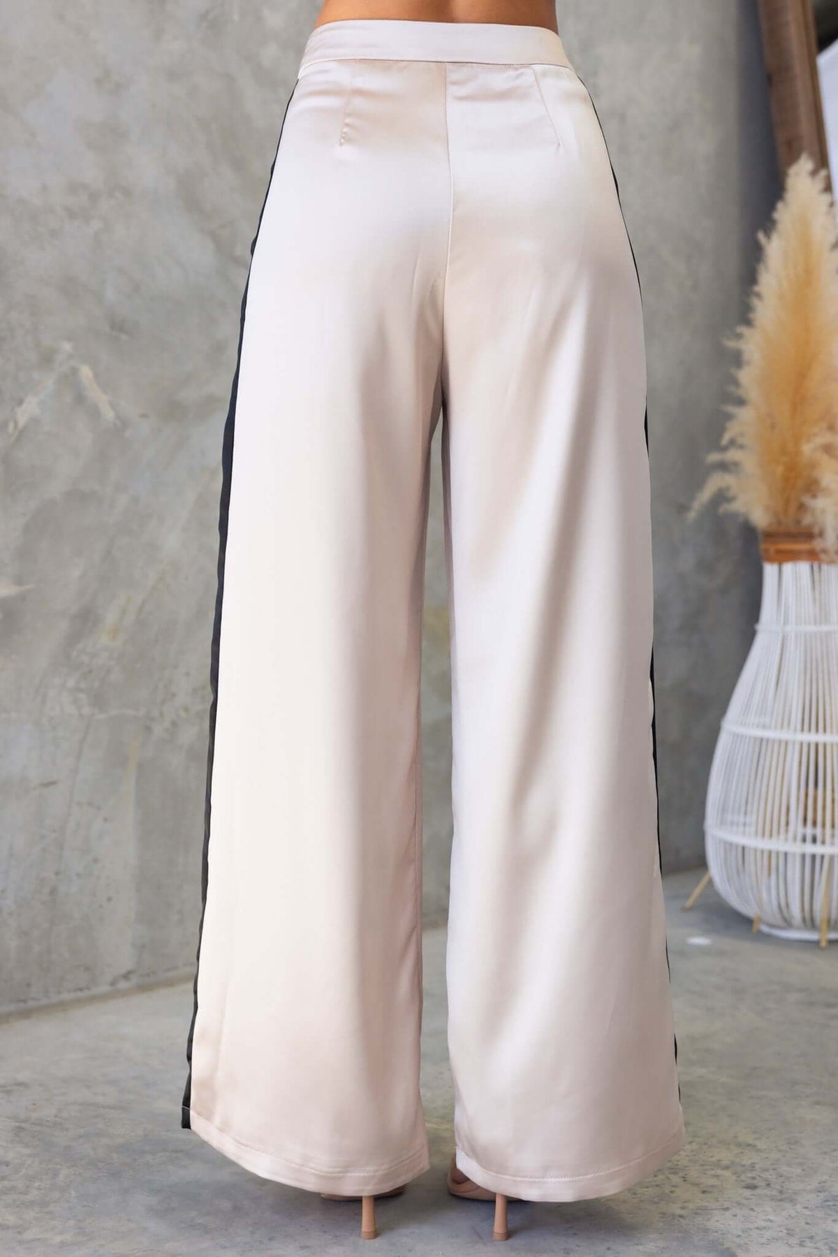 Back view of Tanaya Pants showcasing mid-high waist, satin fabric, and side pockets with an invisible zip.