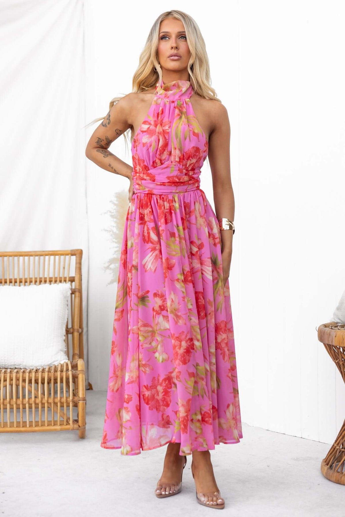 Model wearing Giulianna Maxi Dress, a pink floral halter neck dress with a zip back and lined design.
