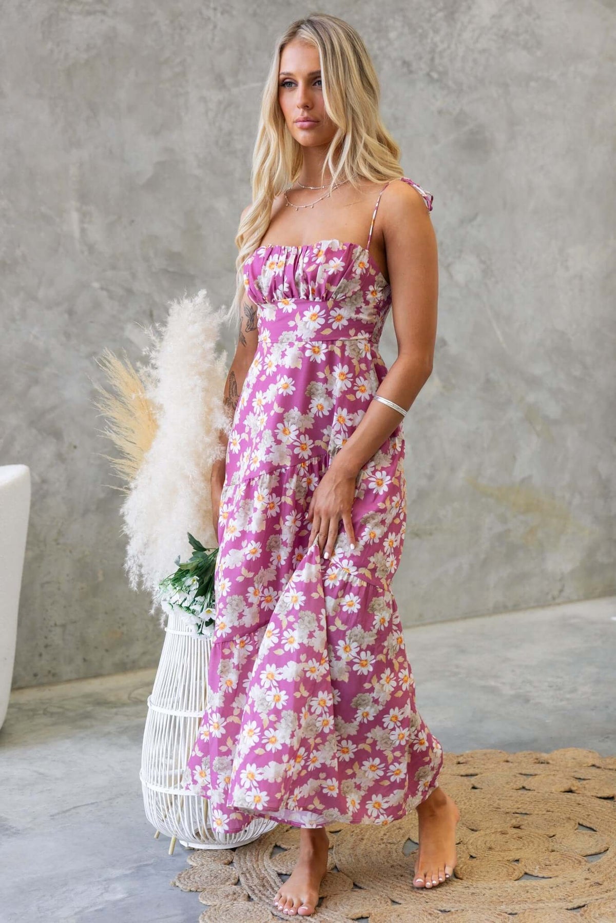 Elegant model in Daring Midi Dress with floral print, showcasing tie straps and cut-out back design.