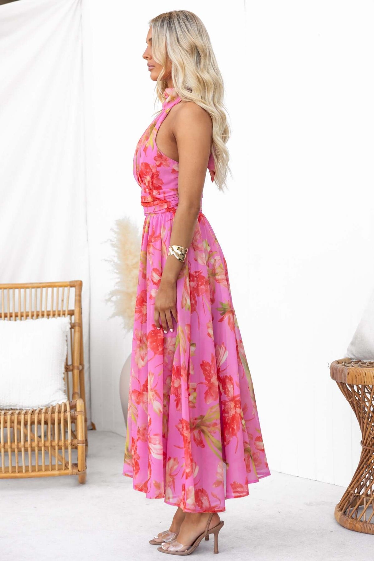 Model wearing Giulianna Maxi Dress with floral print, featuring tie neck and zip back, styled in a bright setting.