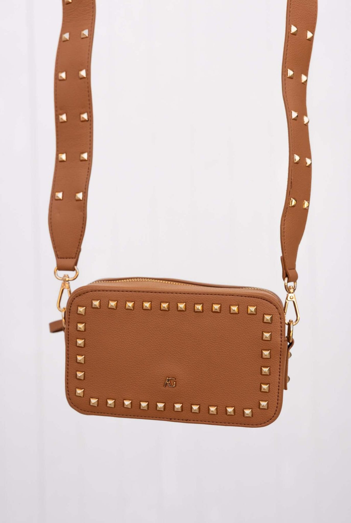 Veronica Crossbody Bag in brown leather with metallic studs and adjustable strap, perfect for dancefloor essentials.