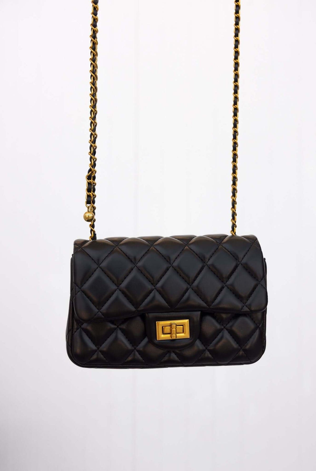 Chic Chelsea Bag in black quilted vegan leather with gold hardware and stylish chain strap.