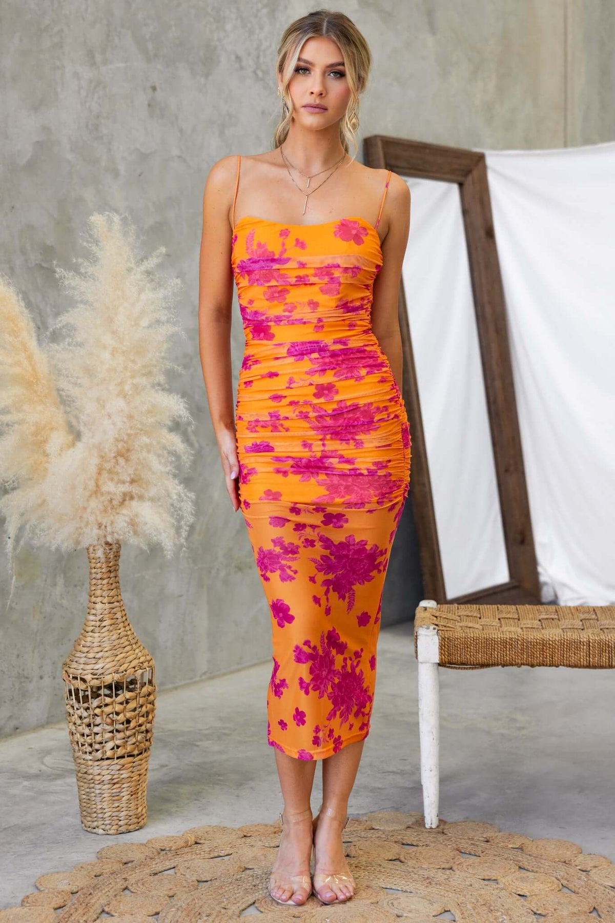 Azriel Midi Dress featuring a mesh overlay, adjustable straps, and a vibrant orange with pink floral print.