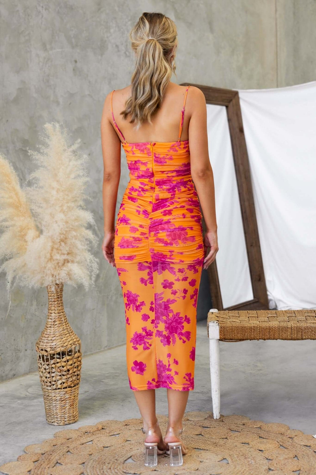 Back view of Azriel Midi Dress in orange and pink floral pattern, featuring adjustable straps and ruched detailing.