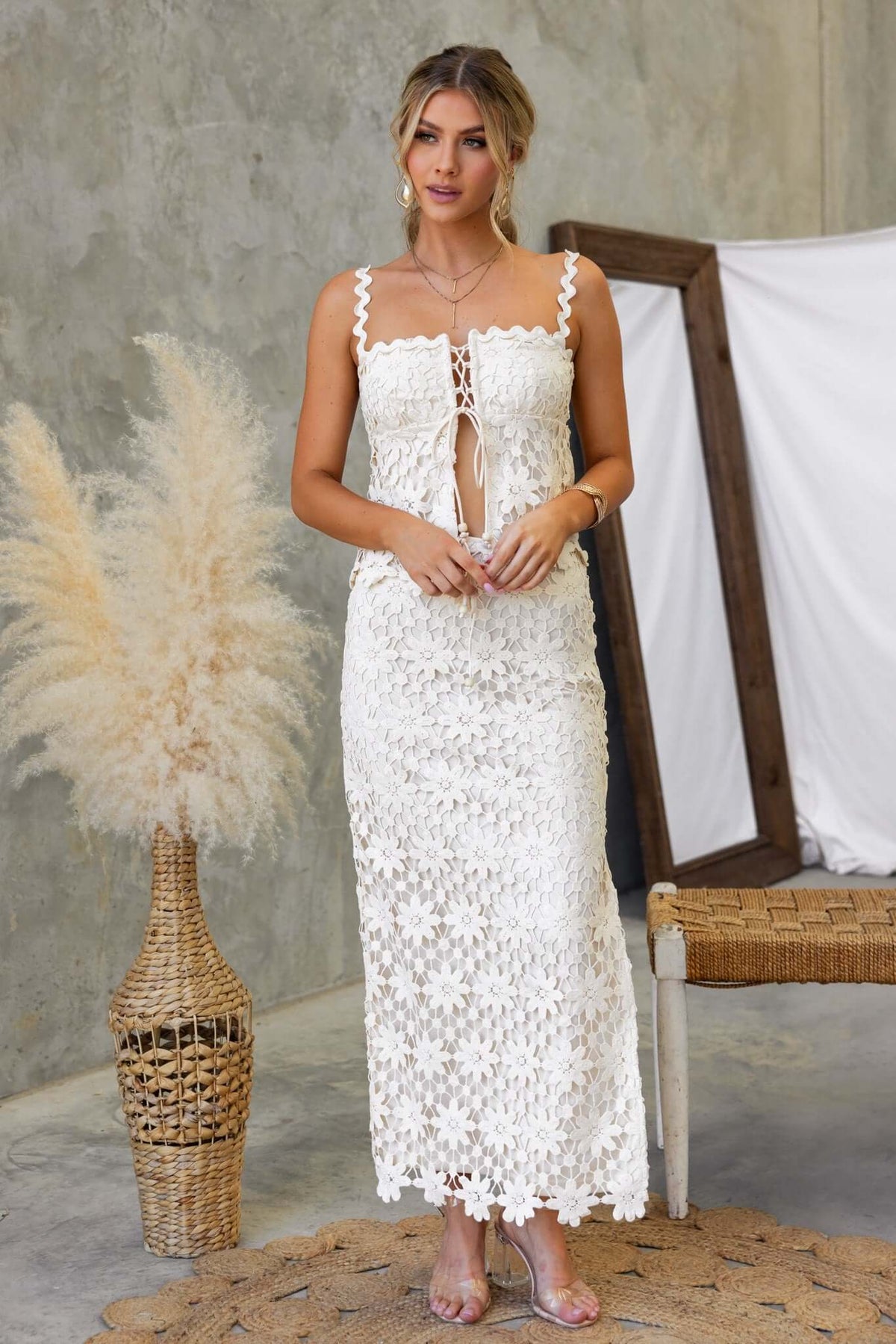 Model wearing the Xenni Top in white Anglaise material with adjustable straps and a tie at the bust, showcasing a stylish summer look.