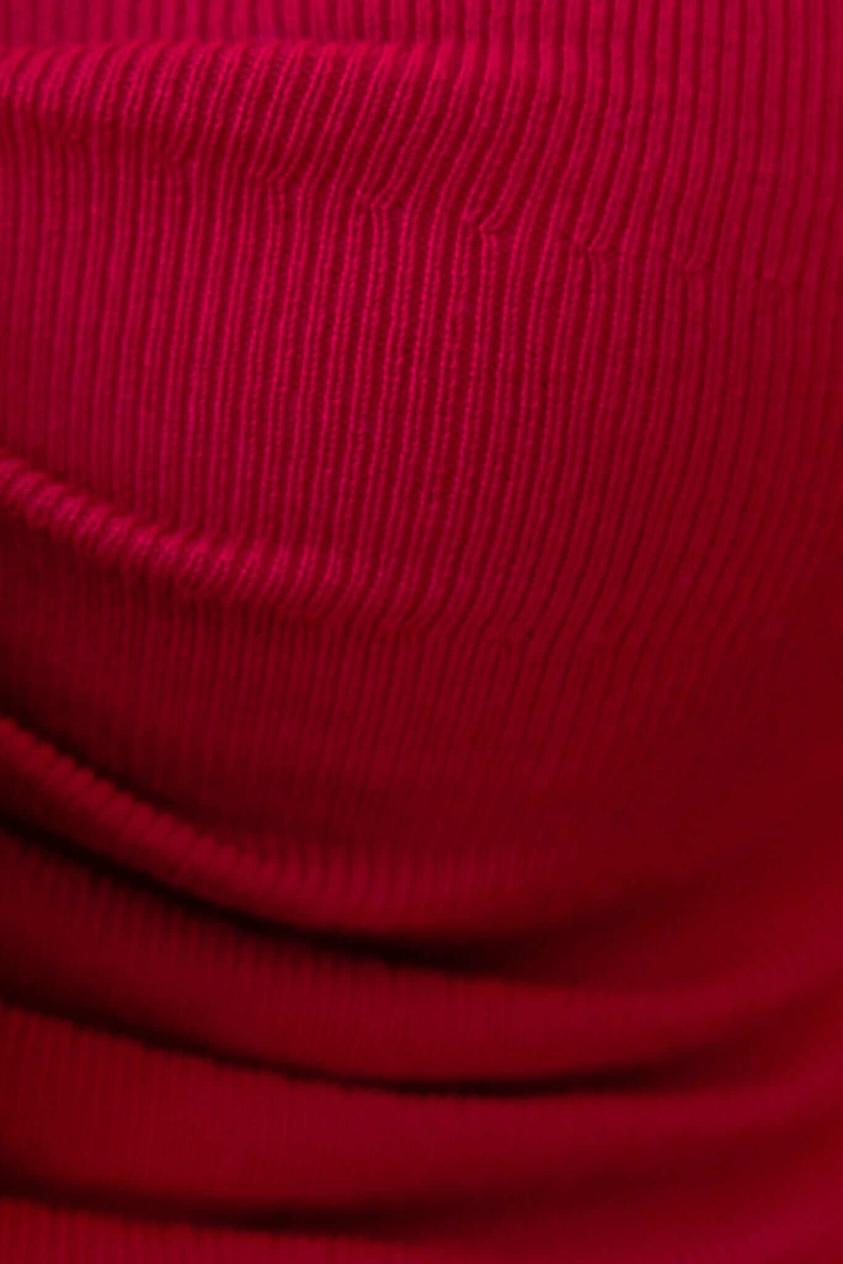Close-up of textured ribbed fabric in vibrant red, showcasing stretch material of the Imani Top.