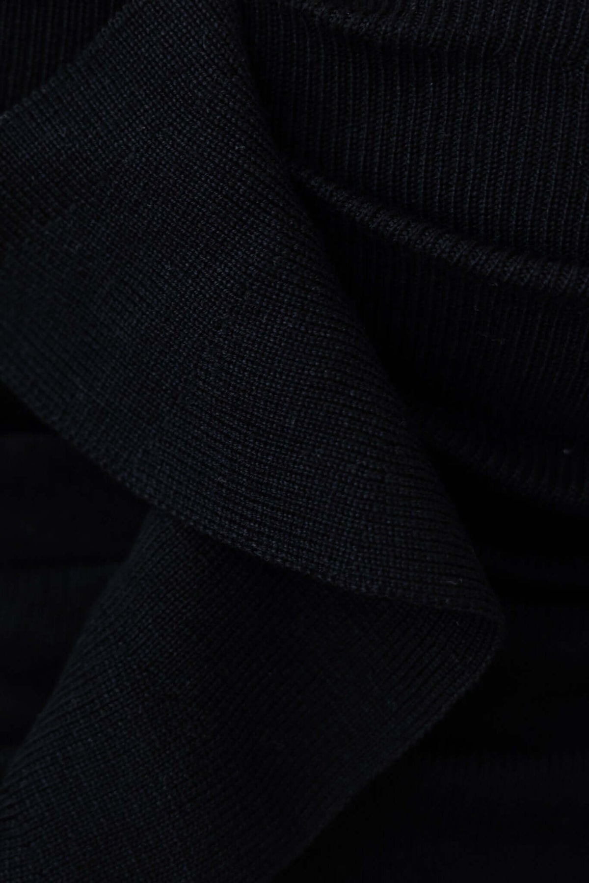 Close-up of the black knit material of the Imani Top, showcasing its soft texture and adjustable strap detail.
