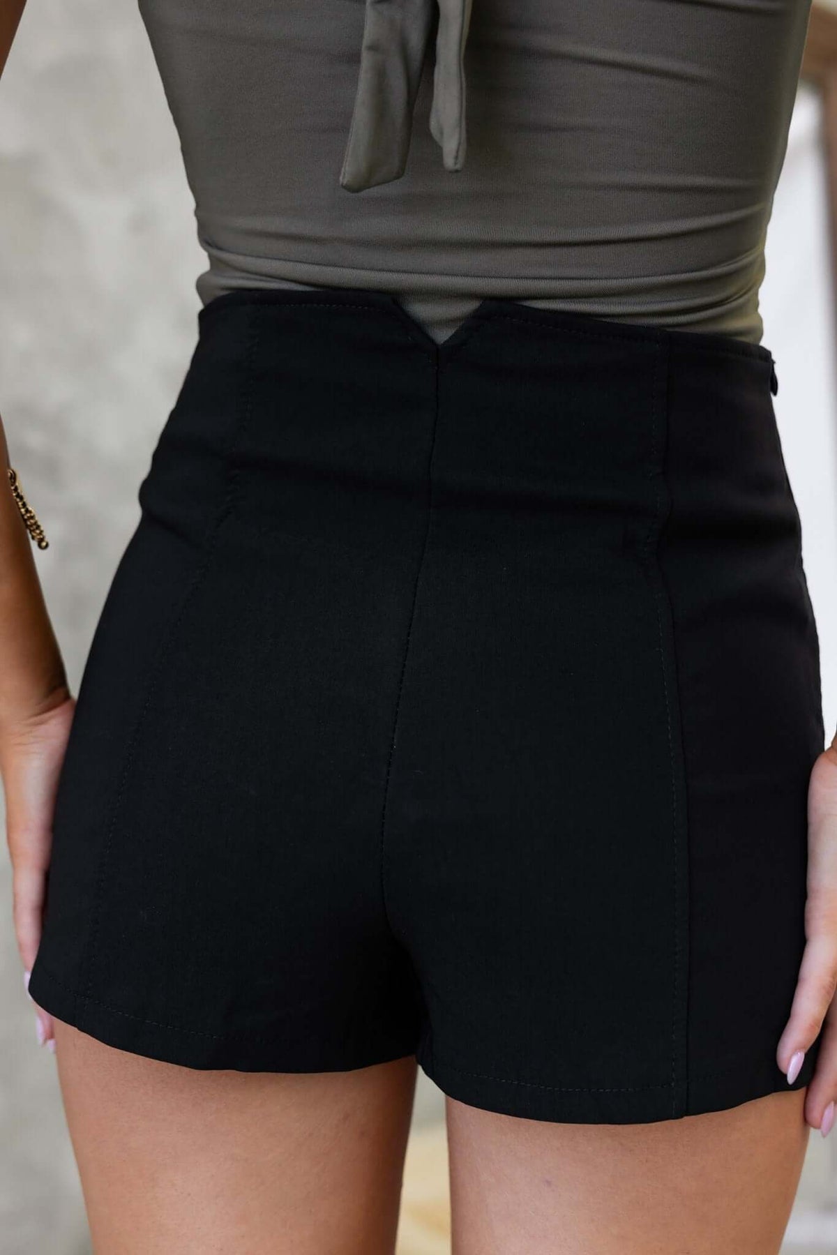 Back view of black Holland shorts with mid-high waist fit and invisible side zip, styled for a trendy look.