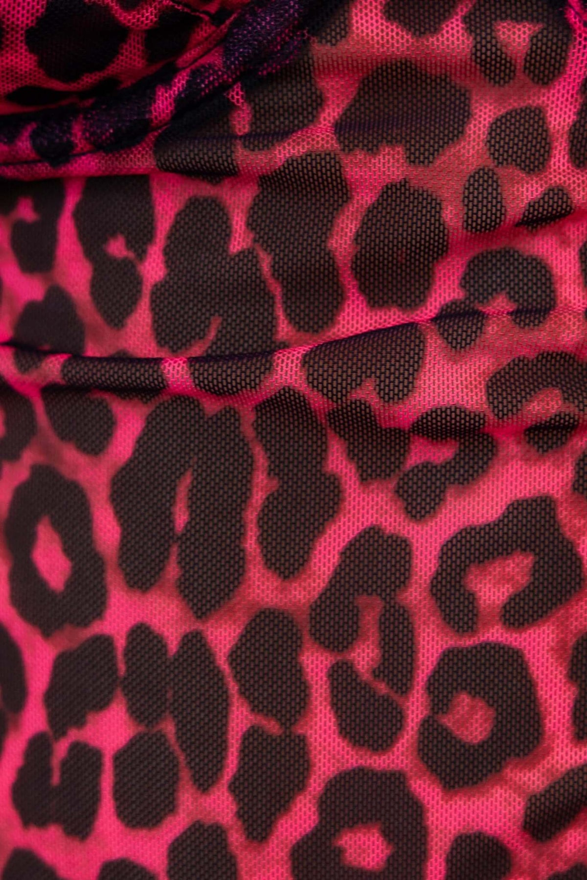 Close-up of pink and black leopard print fabric of the Sparks Bodysuit, featuring a mesh texture.