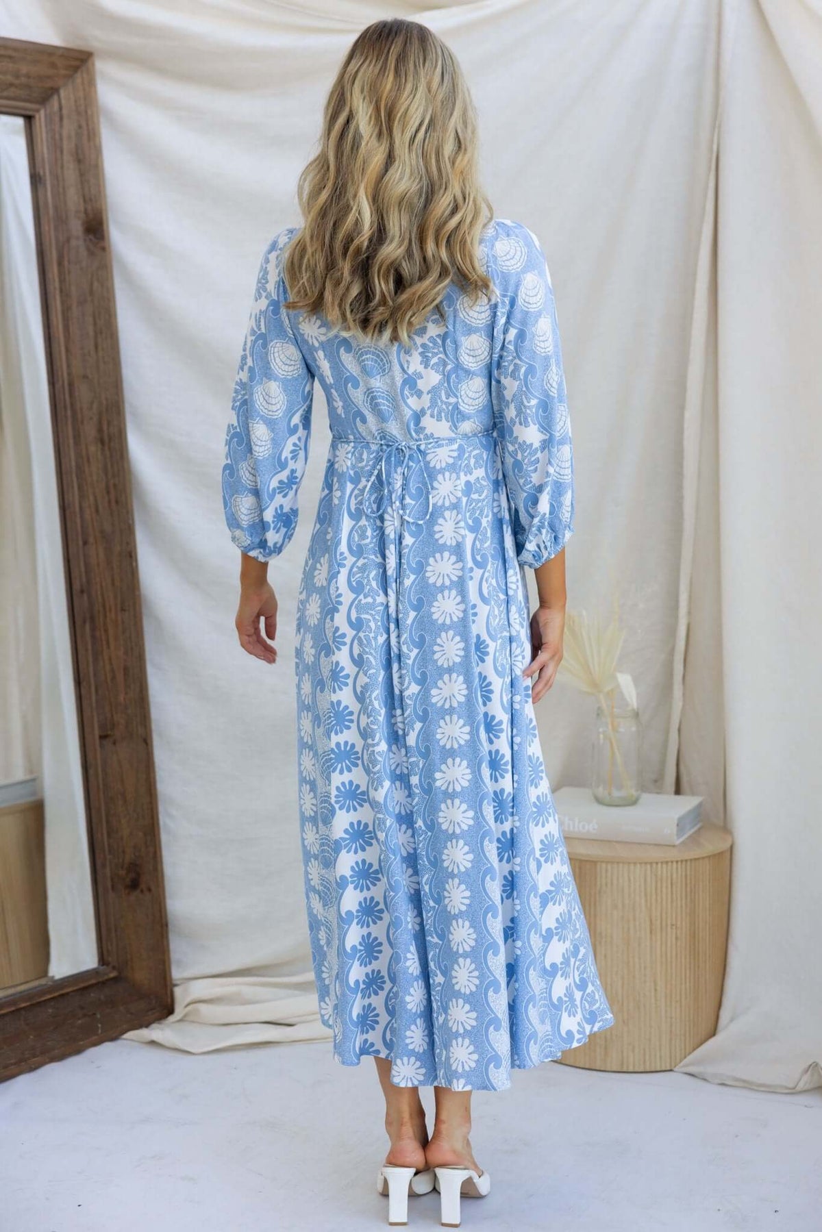 Rear view of the Hartford Maxi Dress, featuring a floral design, V-neckline, and button-up front, perfect for a summer occasion.
