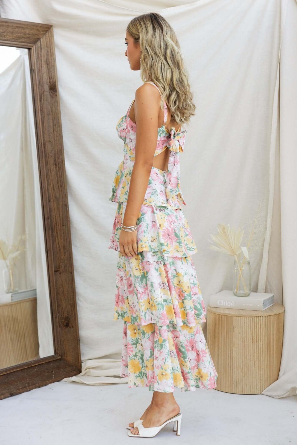 Model showcasing Peyton Maxi Dress with multi-tier ruffle skirt and adjustable straps, styled in a floral pattern.