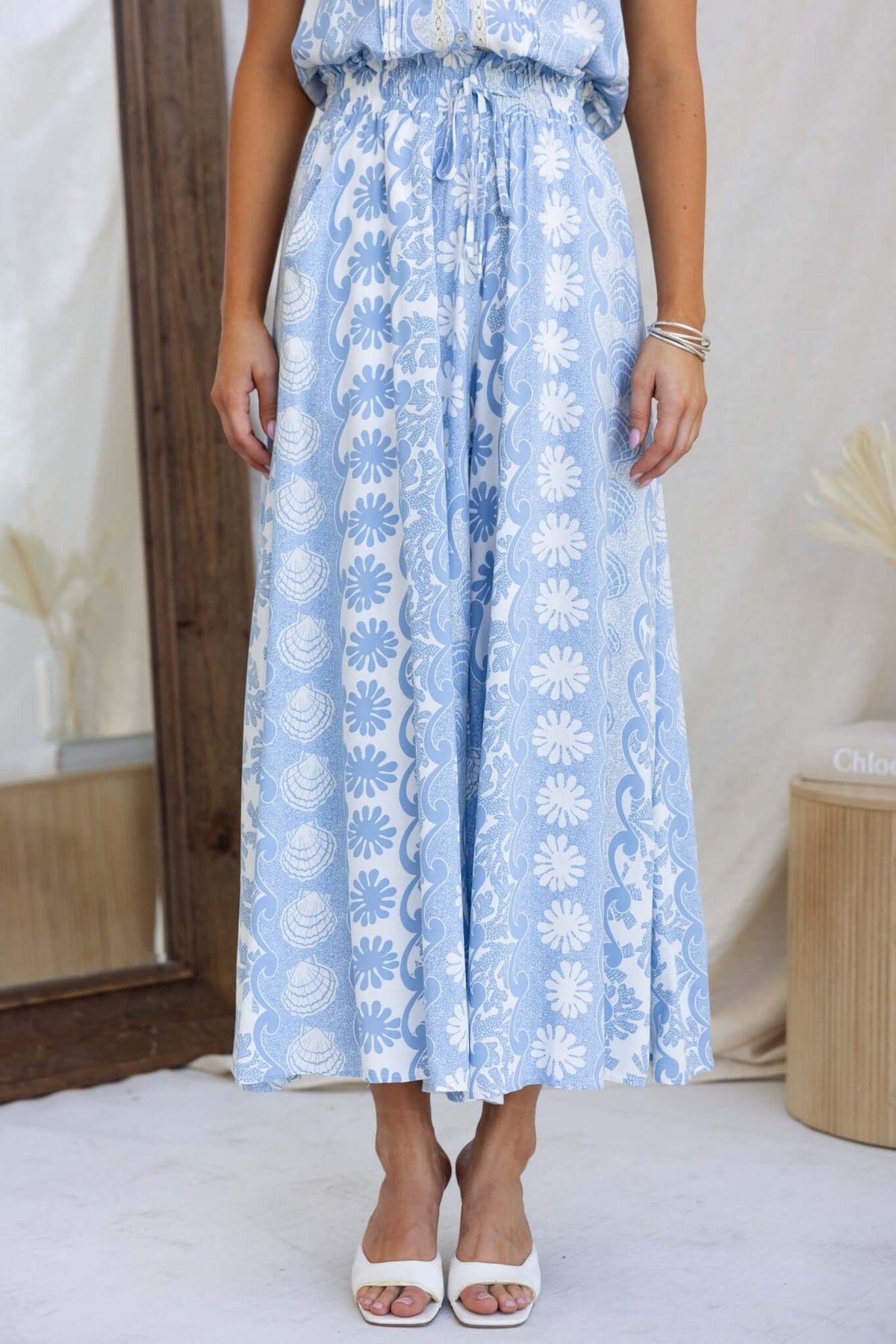 Lunita Pants featuring a mid-high waist, elastic waistband, and floral print in light blue, perfect for warm weather.