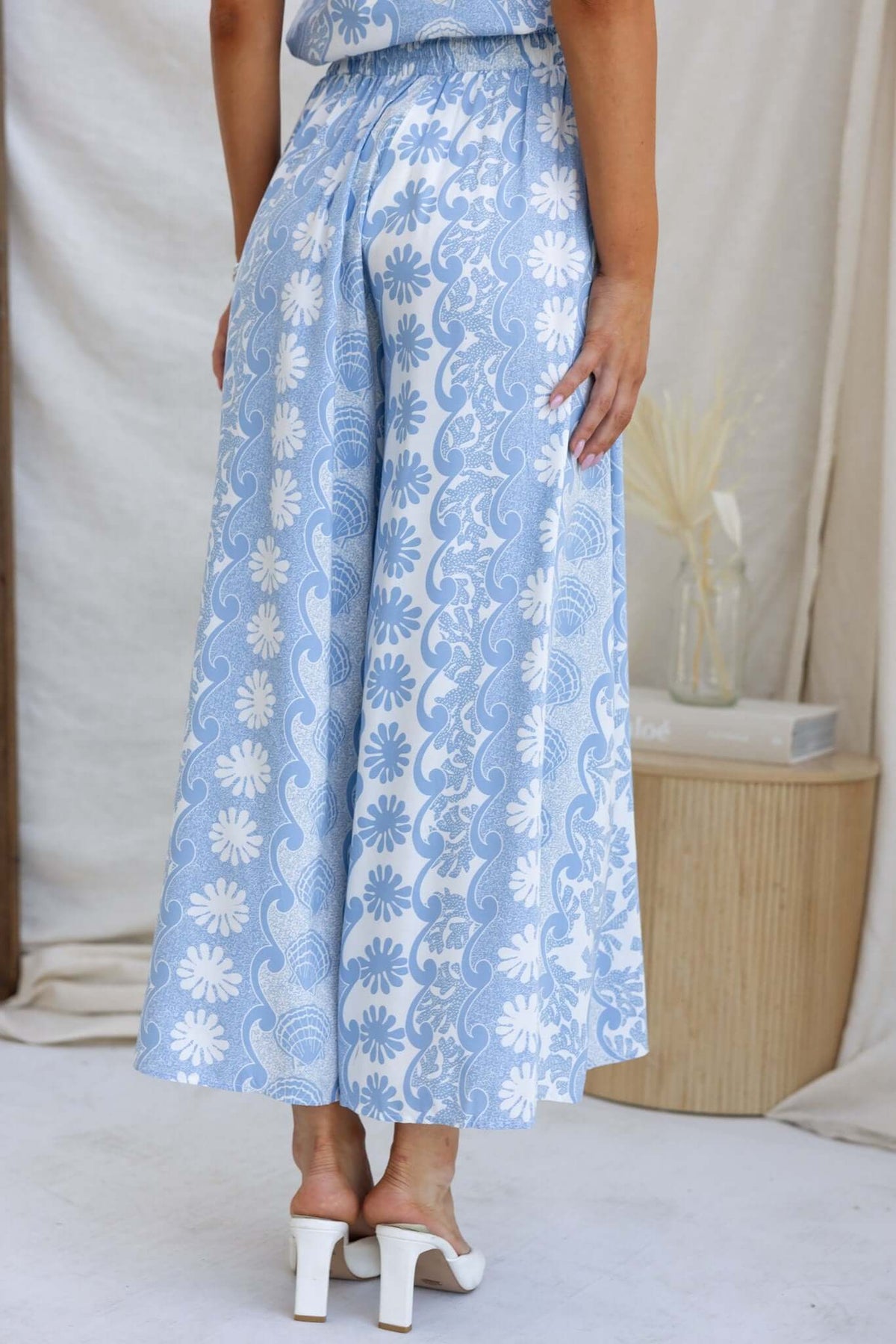 Back view of Lunita Pants in blue with floral pattern, featuring an elastic waistband and wide-leg design.