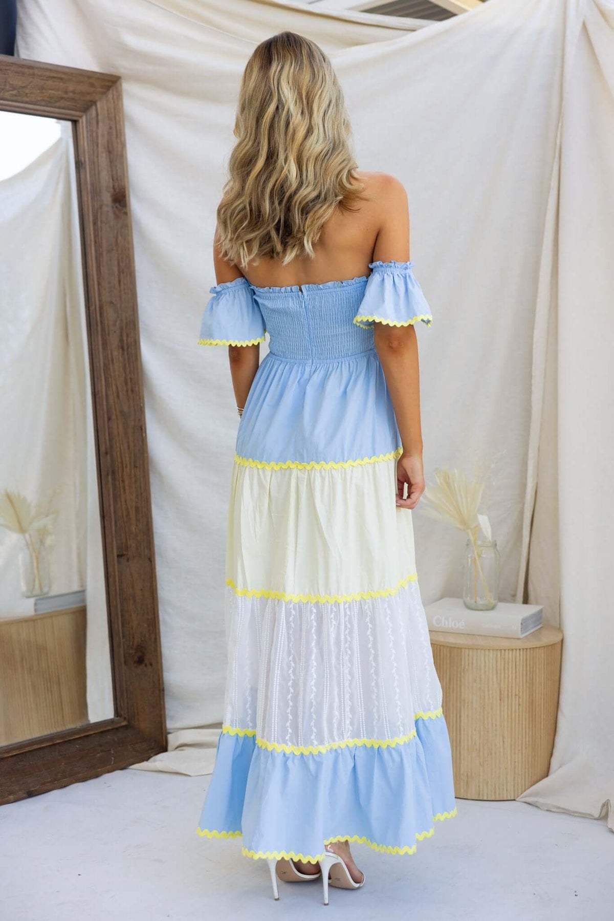 Back view of the Palmer Maxi Dress featuring a smocked bodice and tiered fabric in blue and white colors.