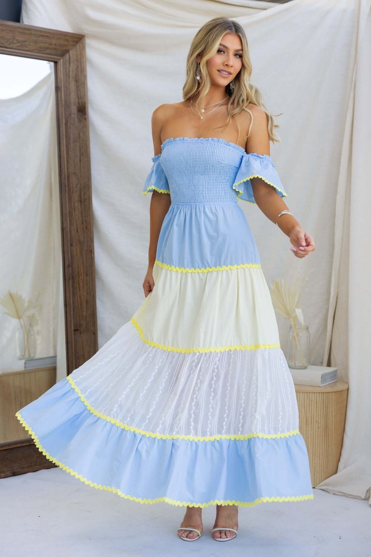 Palmer Maxi Dress featuring a smocked bodice, flowing tiers in blue and white, complemented with yellow lace trim.