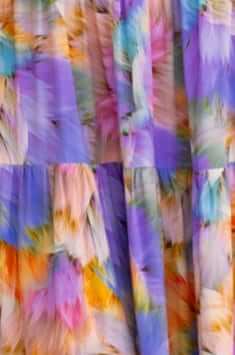 Close-up of colorful, flowing fabric in pastel hues for Emmelina Maxi Dress, showcasing its vibrant pattern and texture.