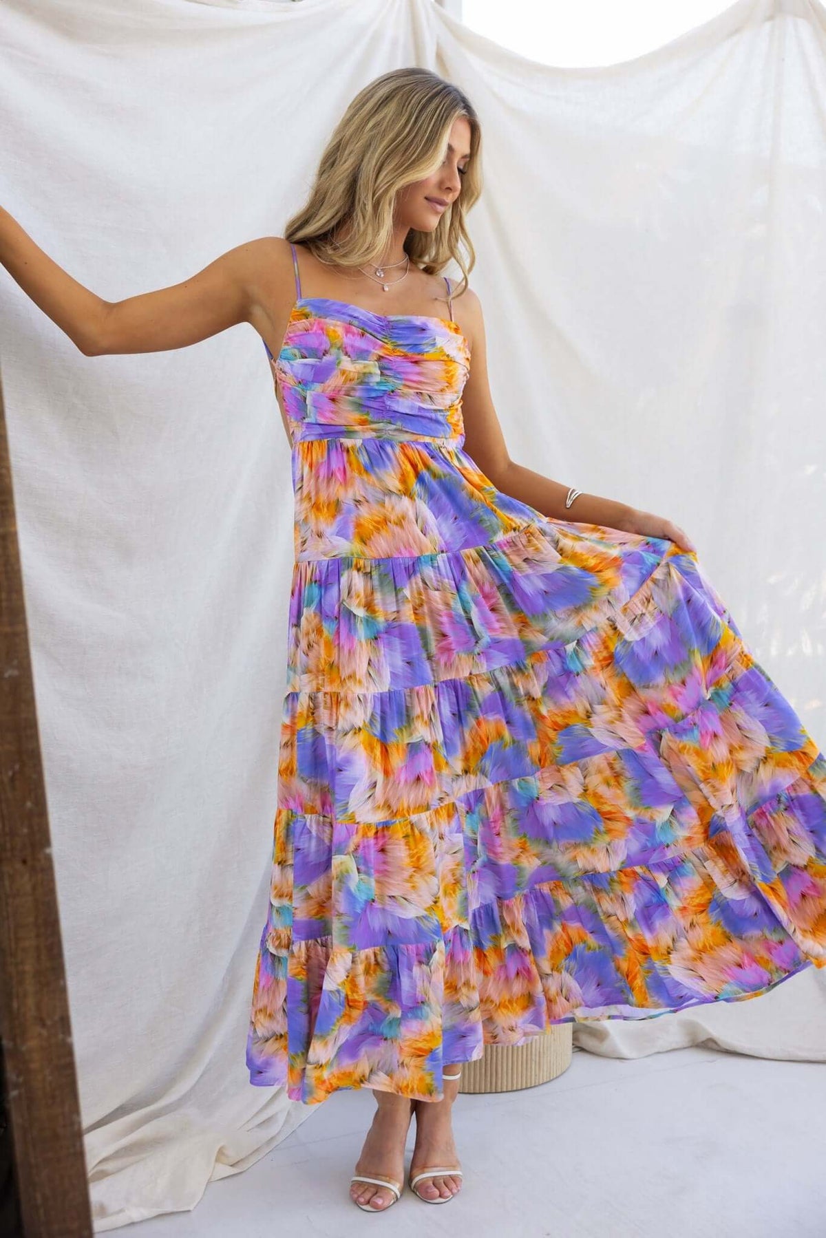 Woman wearing Emmelina Maxi Dress with colorful floral print, showcasing adjustable straps and a flowy design.
