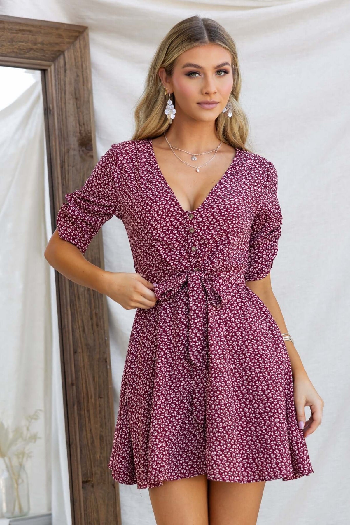 Farsan Dress with V-neckline, button-up front, and removable tie, featuring floral pattern and pockets.