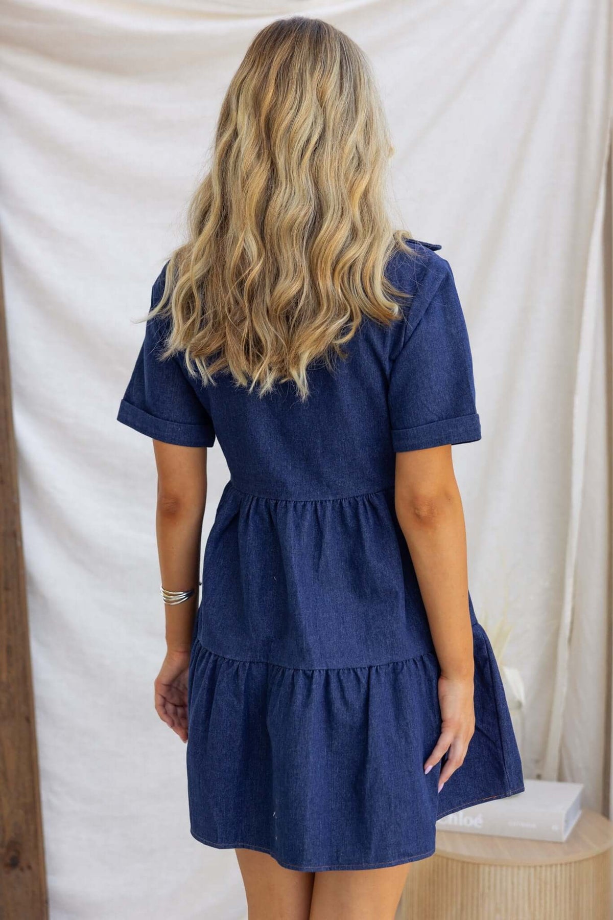 Back view of Jessy Denim Dress featuring a tiered design and short sleeves, perfect for casual wear.