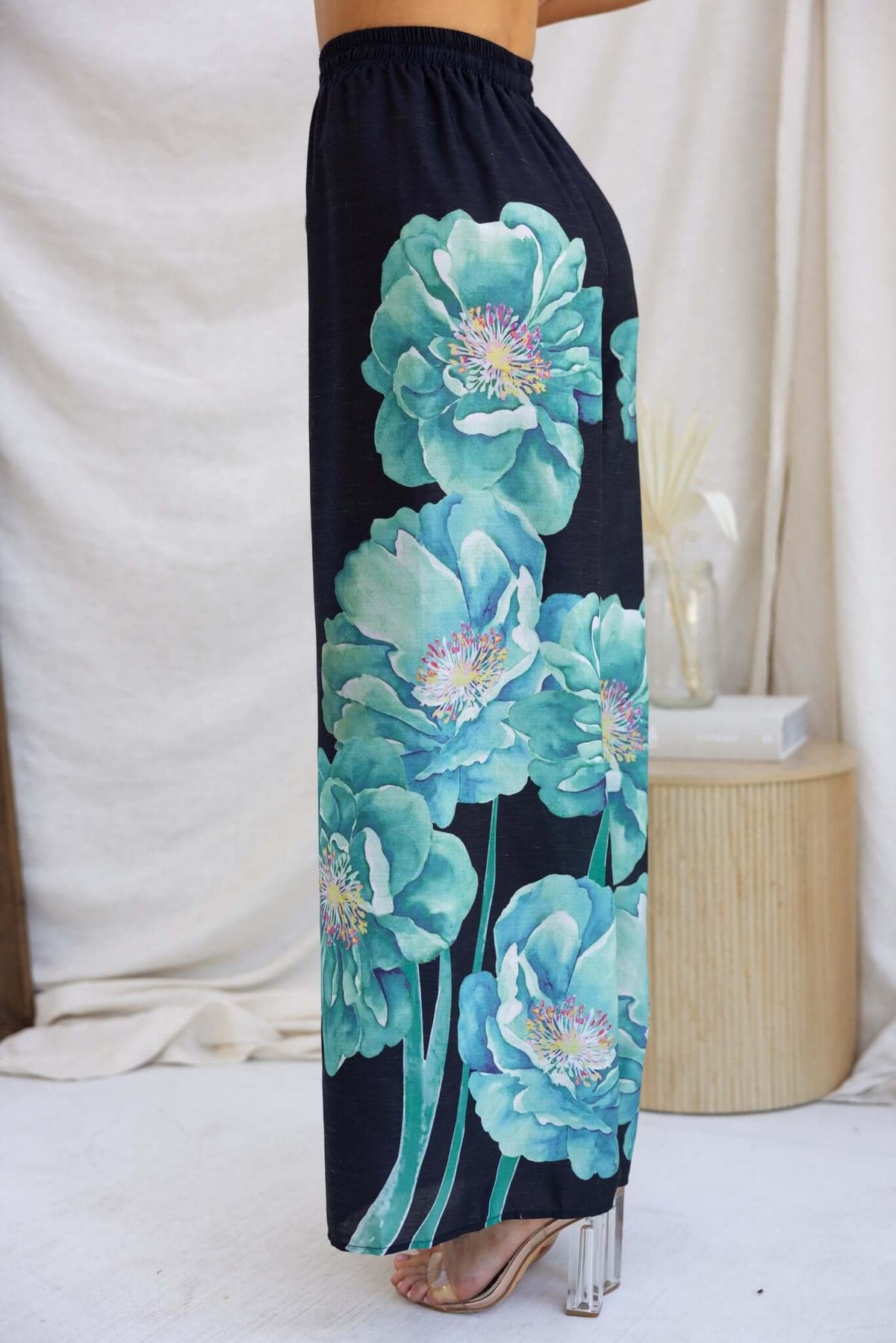 Faly Pants featuring a vibrant floral pattern on a black background, showcasing a mid-high waist fit and lightweight cotton material.