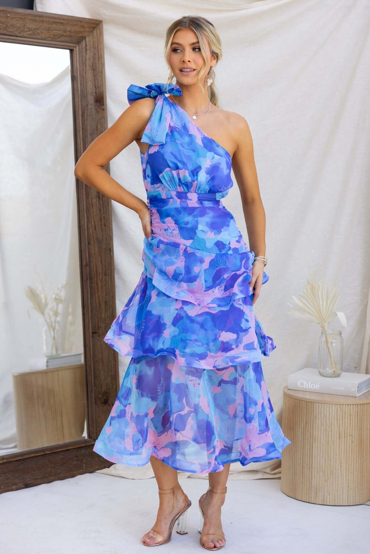 Sherbert Midi Dress featuring one-shoulder neckline, ruffle hem, and tie detail in vibrant blue and purple hues.