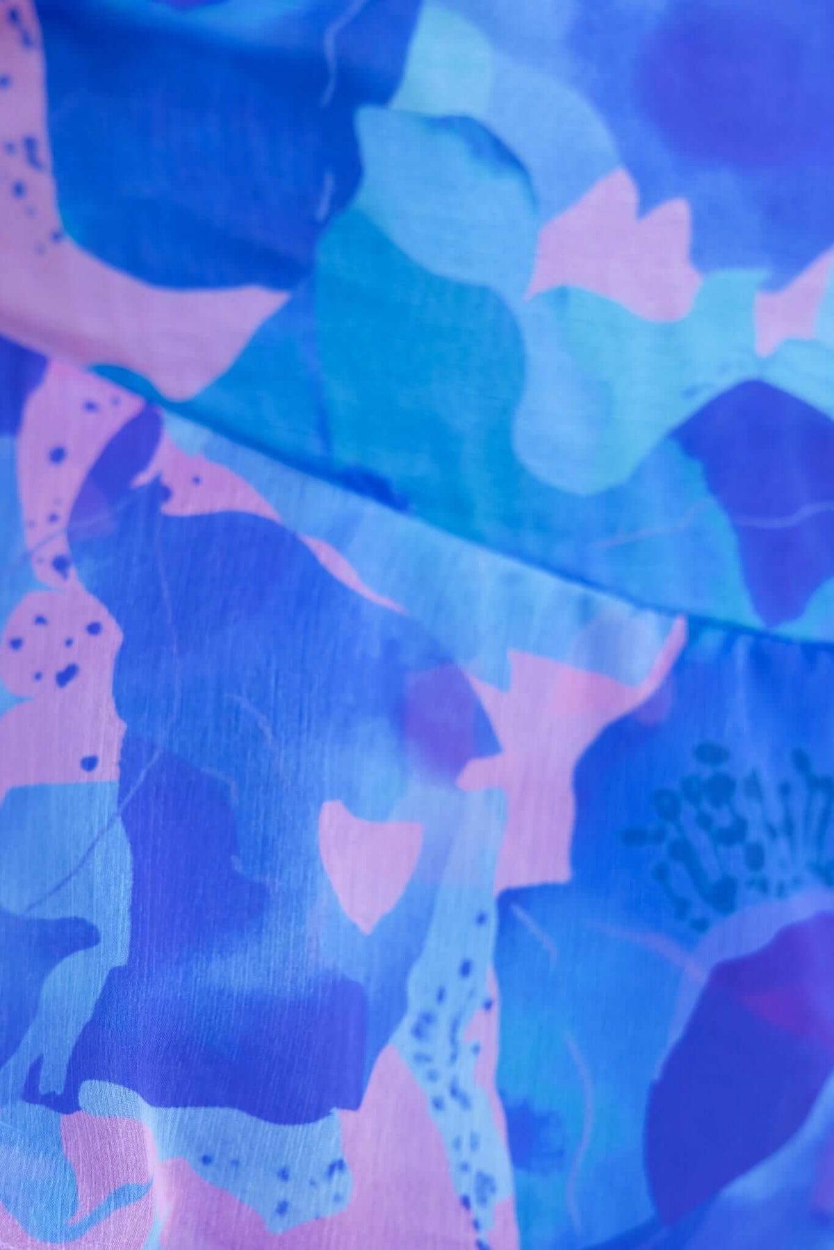 Close-up of colorful floral print fabric on Sherbert Midi Dress, showcasing blue and pink hues.
