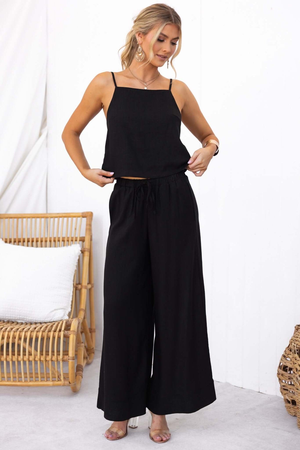 Model wearing black Frances Top with adjustable straps and flowy pants, showcasing a stylish and comfortable linen look.