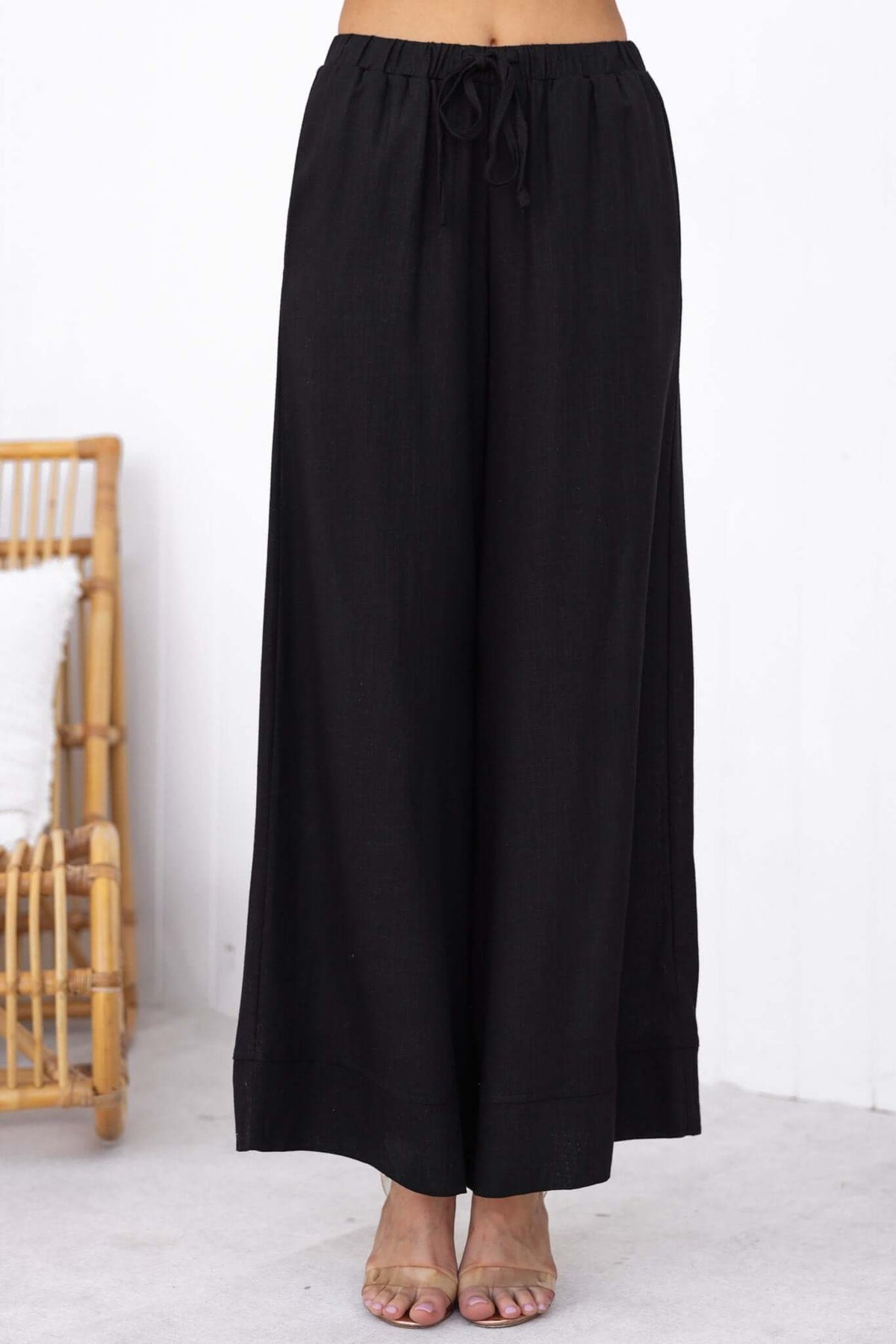Black Frances Pants with elastic waistband, featuring pockets and a linen look, styled for casual wear.