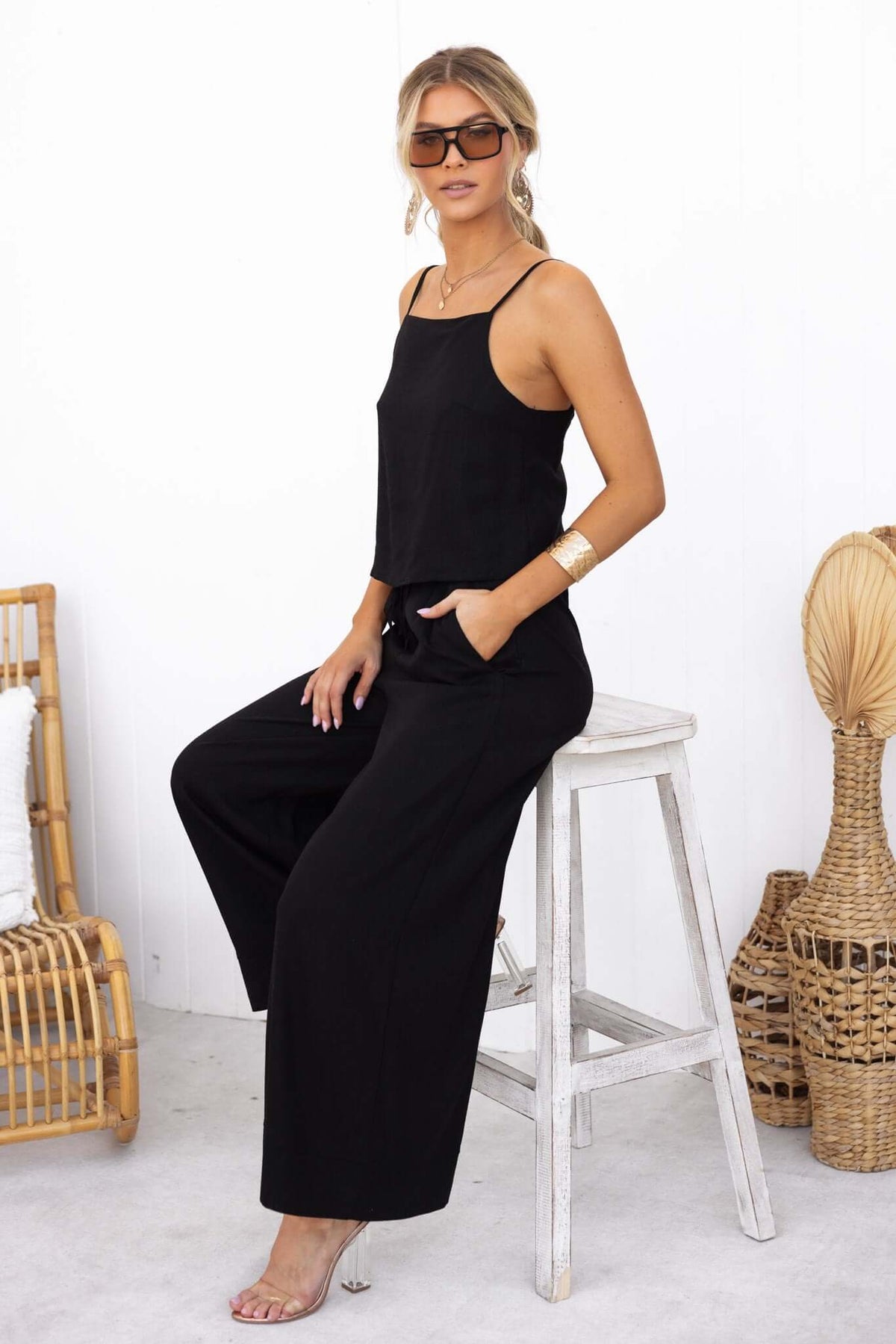 Model wearing Frances Pants in black with elastic waistband and pockets, styled with a chic top and sunglasses.