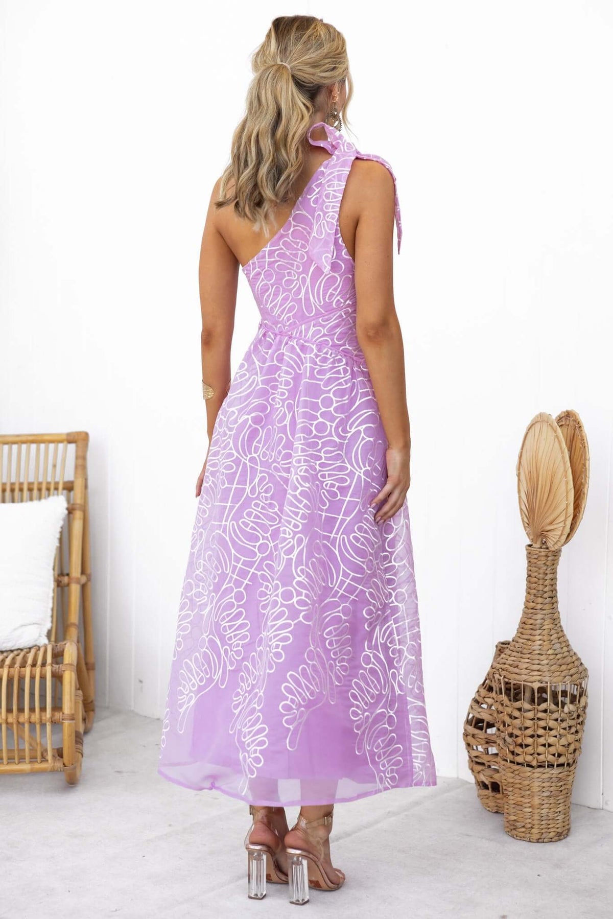 Back view of Haraka Midi Dress in chiffon, featuring a one-shoulder tie strap and elegant floral pattern.