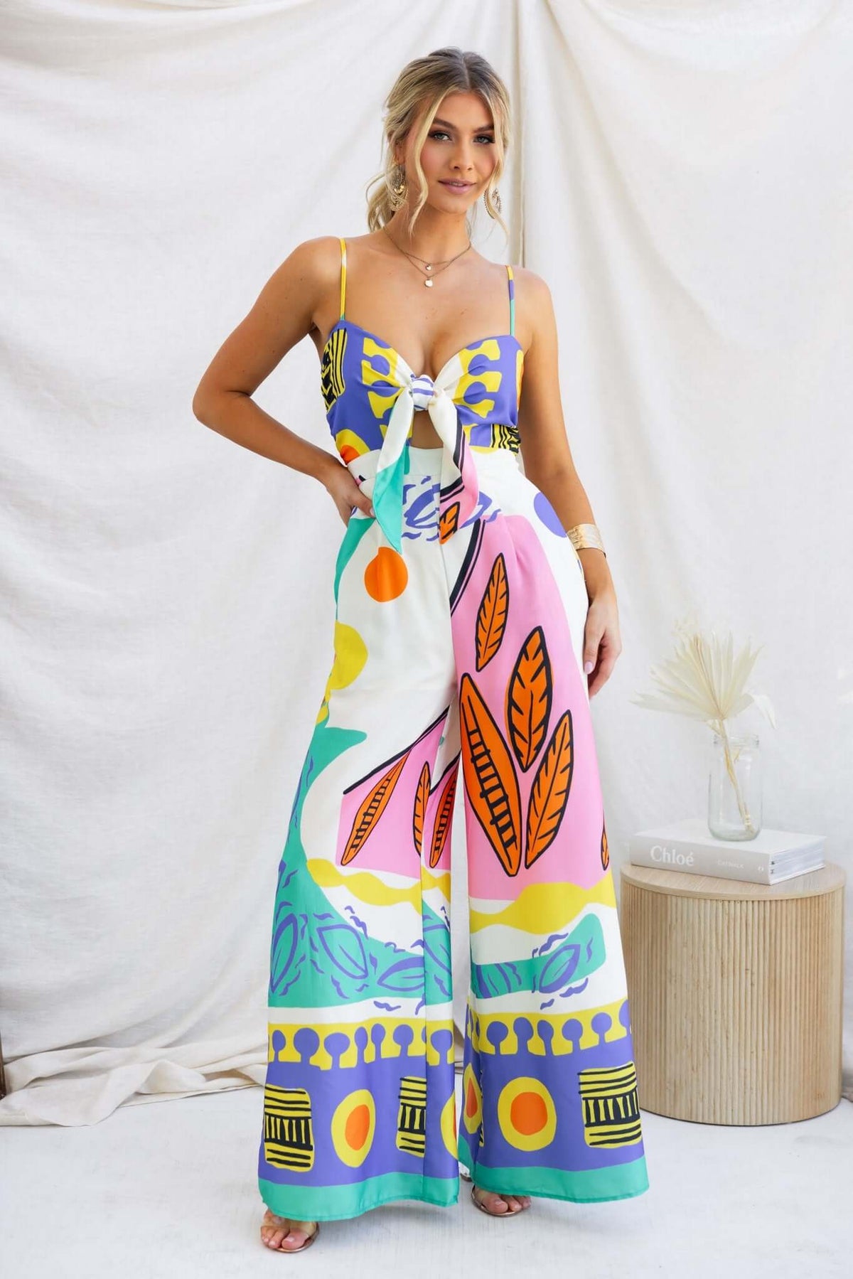 Colorful Sun Dazed Jumpsuit featuring adjustable straps, tie at bust, and pockets against a neutral backdrop.