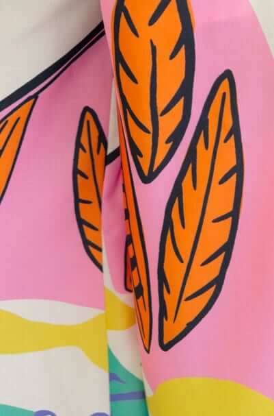 Colorful leaf print close-up on fabric of the Sun Dazed Jumpsuit, showcasing vibrant pink and orange hues.