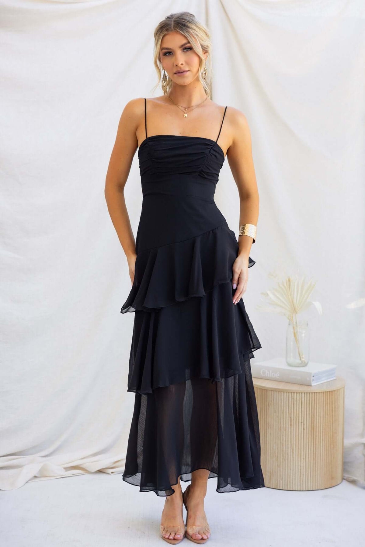 Elegant Saphina Maxi Dress in black with adjustable straps and multi-tier ruffle skirt, perfect for special occasions.
