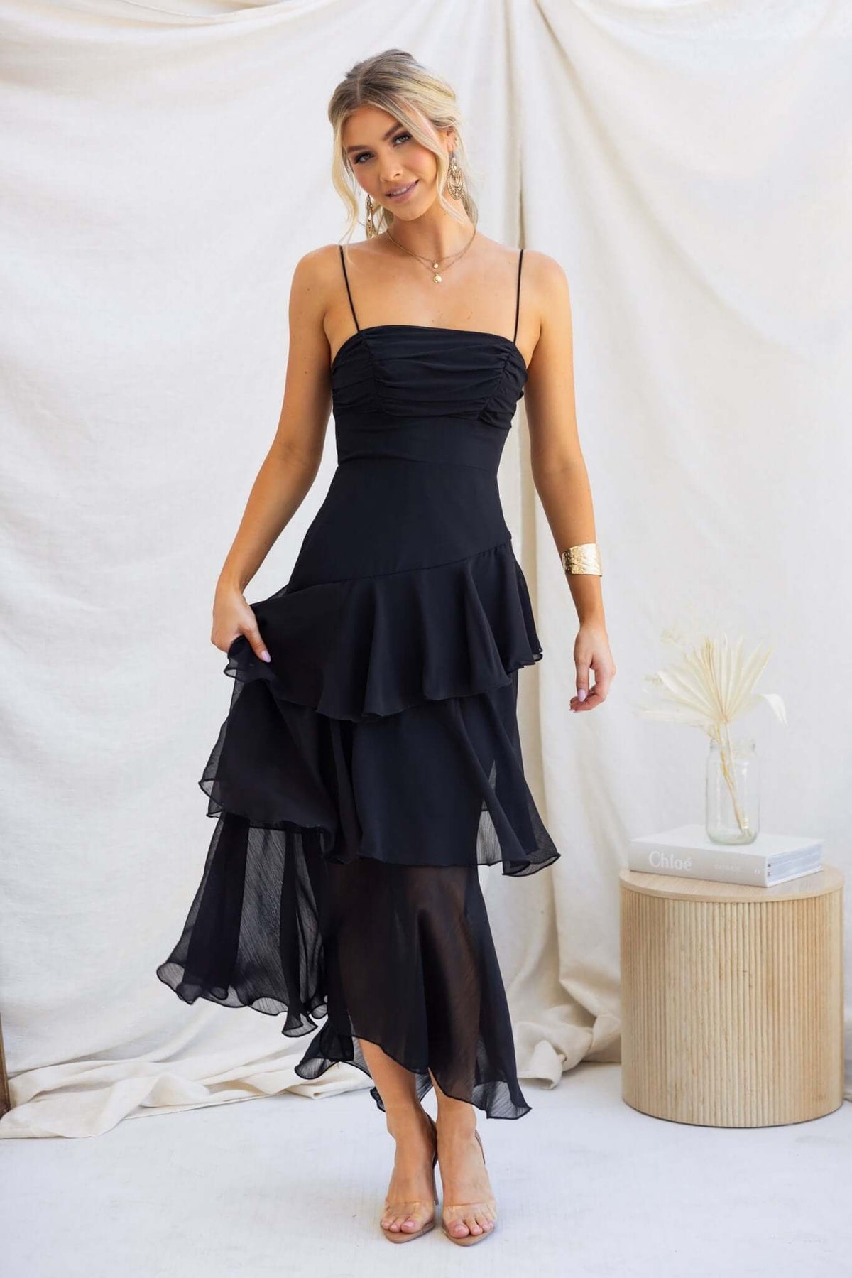 Saphina Maxi Dress in black with adjustable straps and multi-tier ruffle skirt, styled with chiffon material and elegant design.