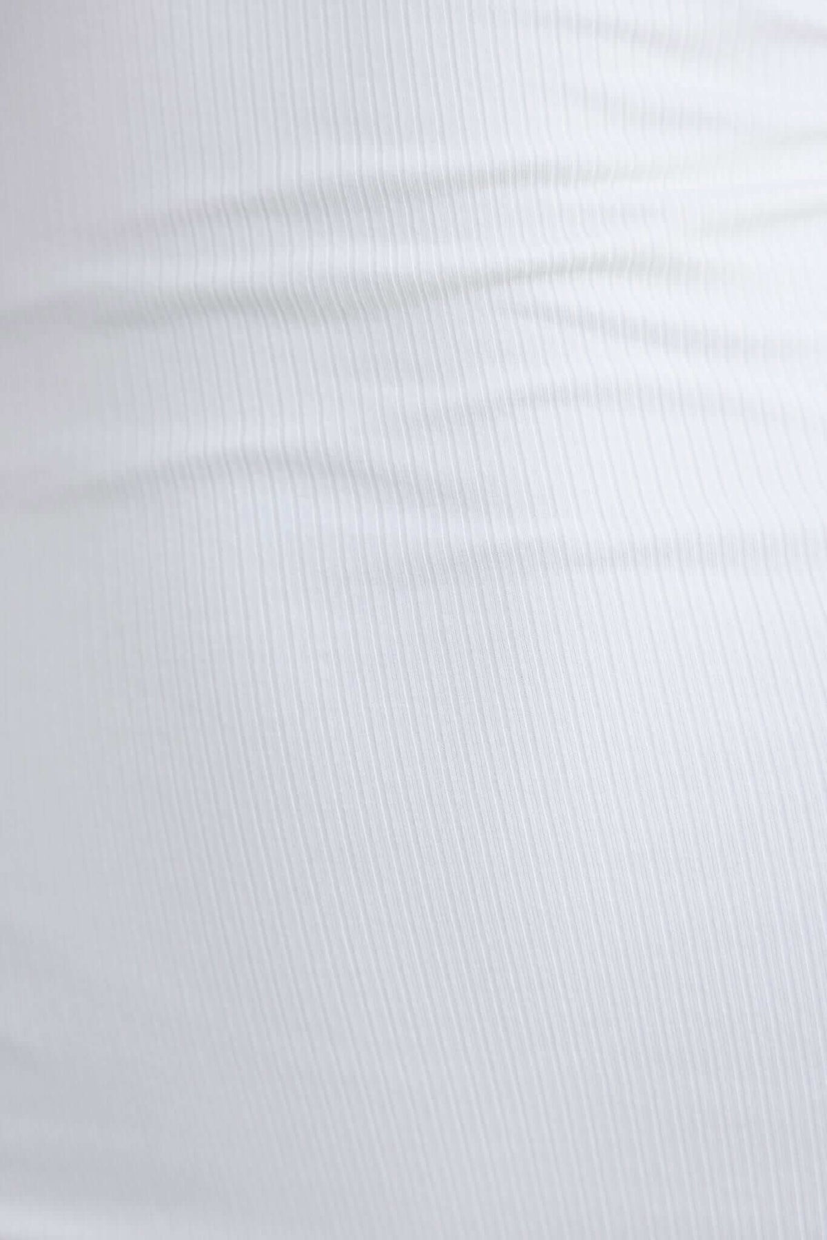 Close-up of a textured white ribbed fabric, perfect for stretchy dresses like the Carla Dress.