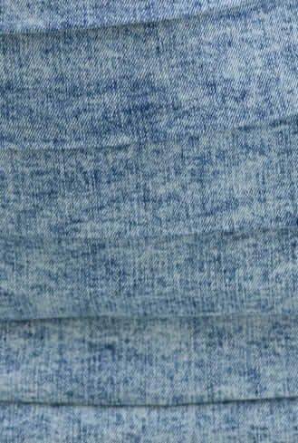 Close-up of denim fabric showcasing pleats and texture, perfect for a stylish dress.