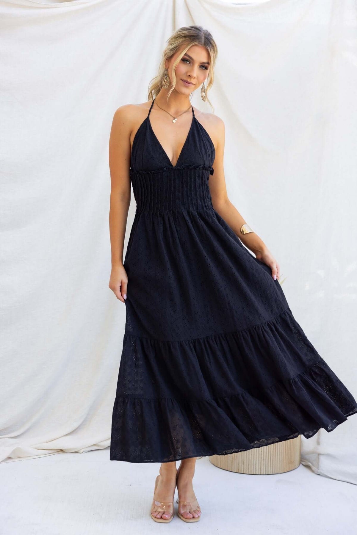 Model wearing black Bisbee Maxi Dress with tie straps, elastic back, and pockets against a neutral backdrop.