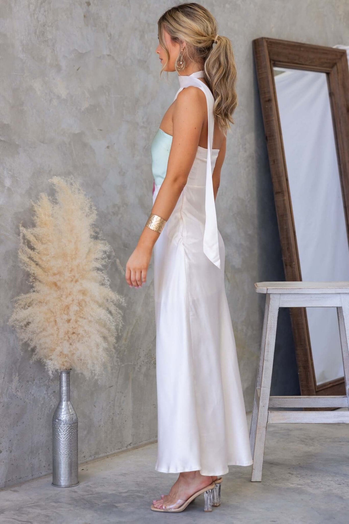 Side view of woman in My Touch Maxi Dress, featuring satin finish, removable strap, and elegant styling.
