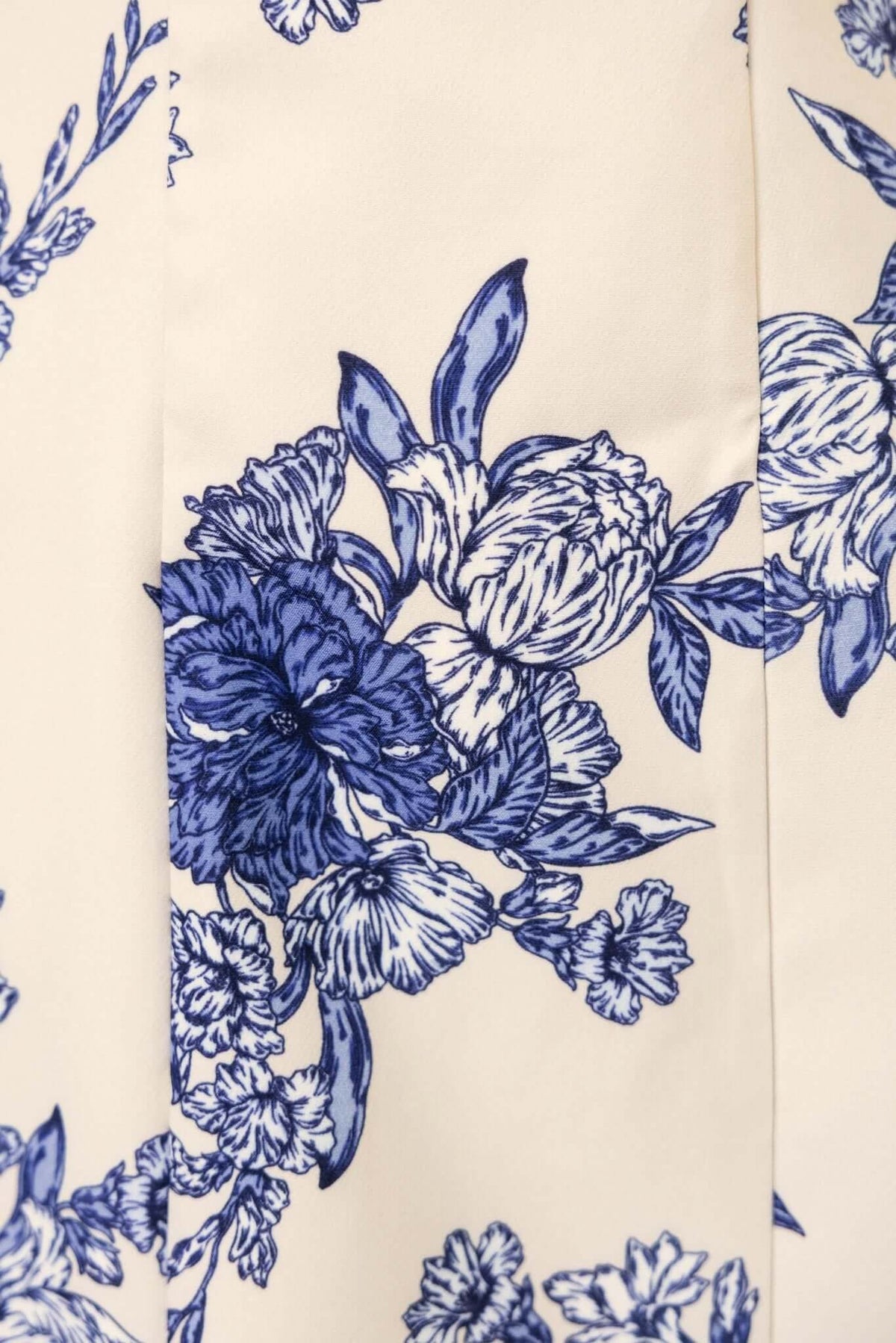 Close-up of floral print in blue and cream on a Demure Dress, showcasing intricate flower design and details.