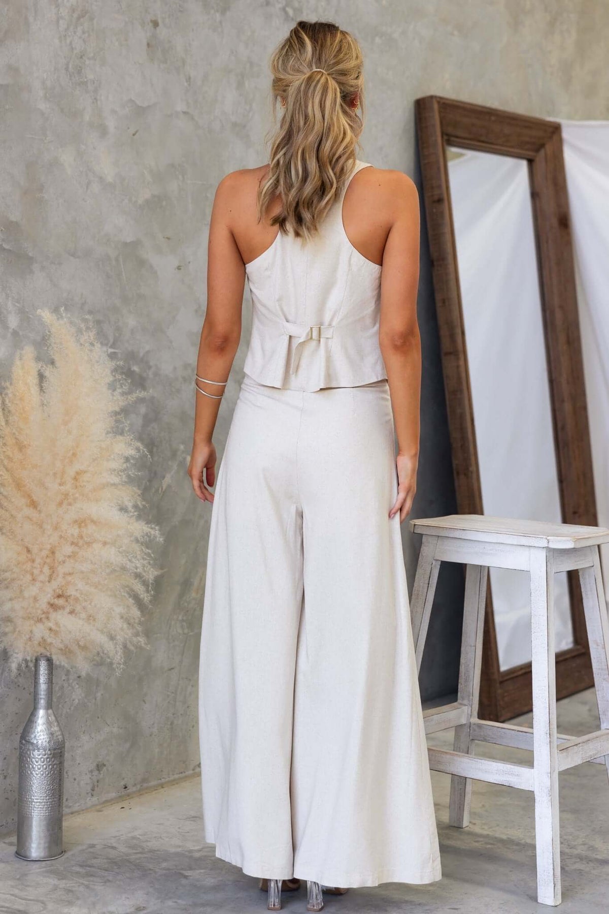 Back view of Urbanne Set featuring a linen-style vest top and wide-leg pants in a soft beige color.