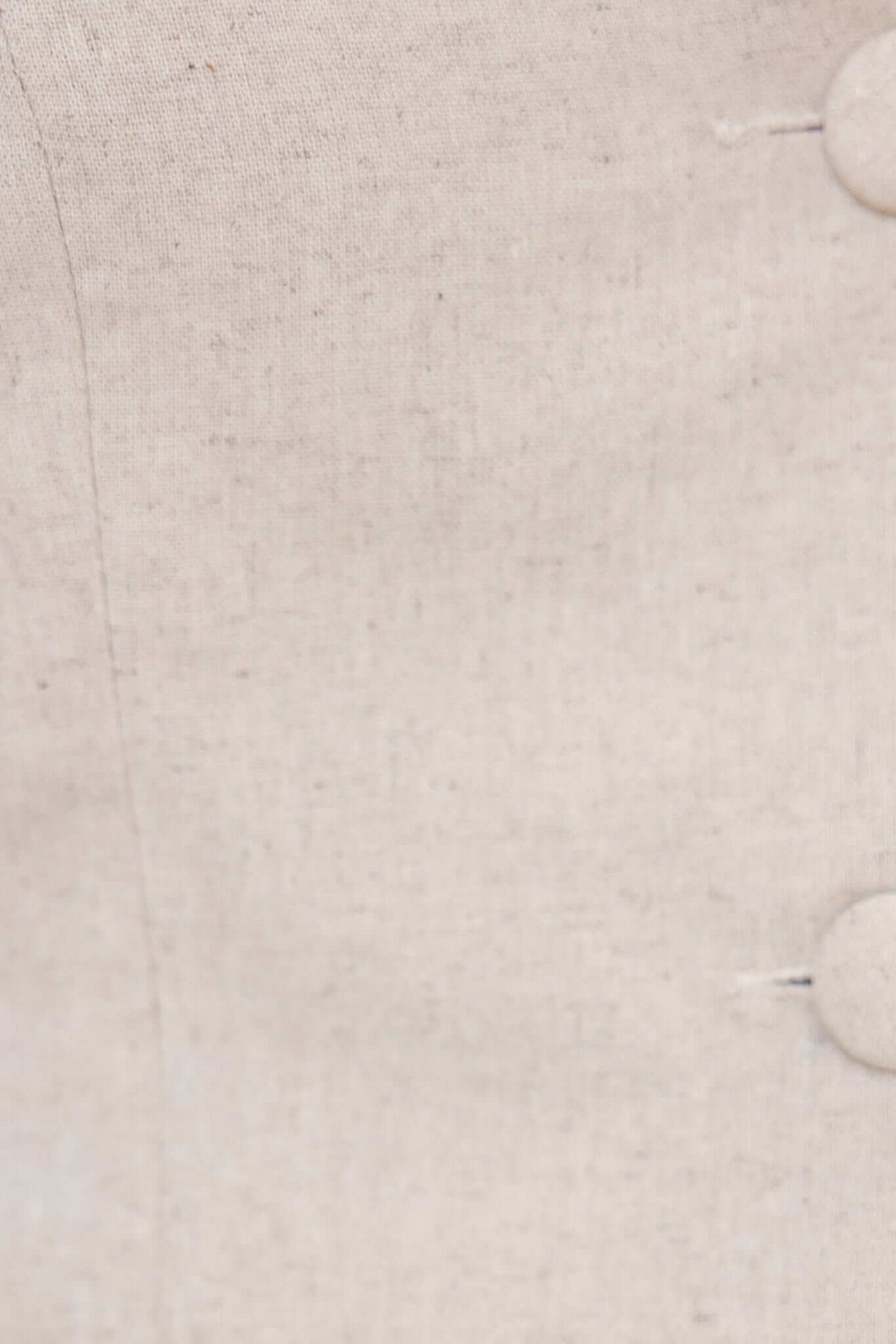 Close-up of linen fabric with button detail, showcasing texture and color for Urbanne Set.