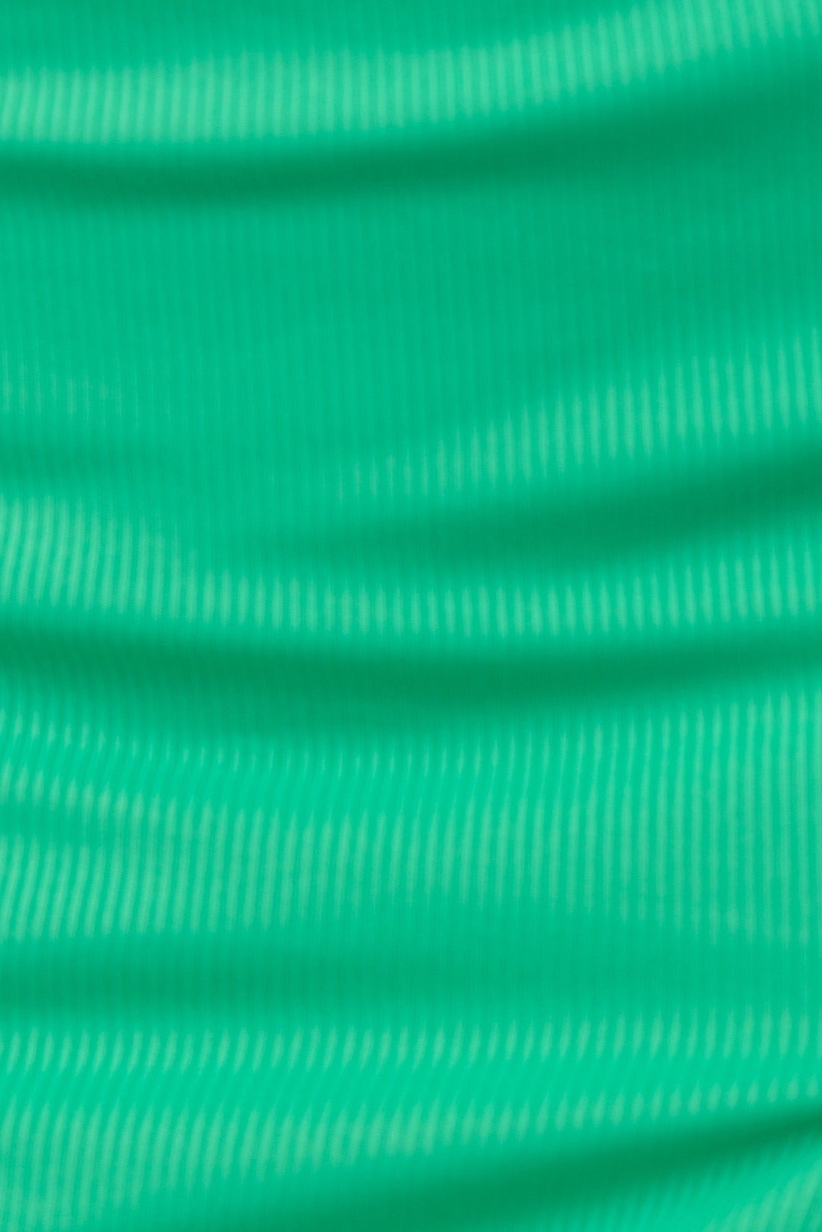 Close-up of ribbed green fabric showcasing texture, perfect for a comfortable and stretchy top.