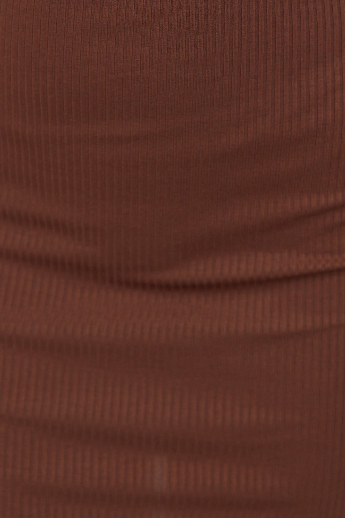 Close-up of ribbed brown fabric showcasing texture and stretch, perfect for a stylish dress.