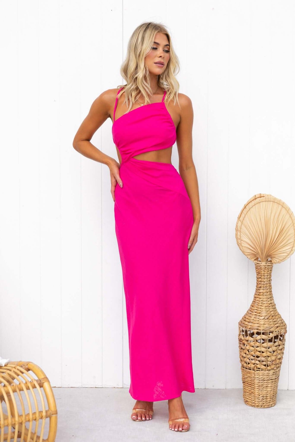 Model in pink Aradia Midi Dress with cut-out waist and adjustable straps, showcasing a stylish summer look.
