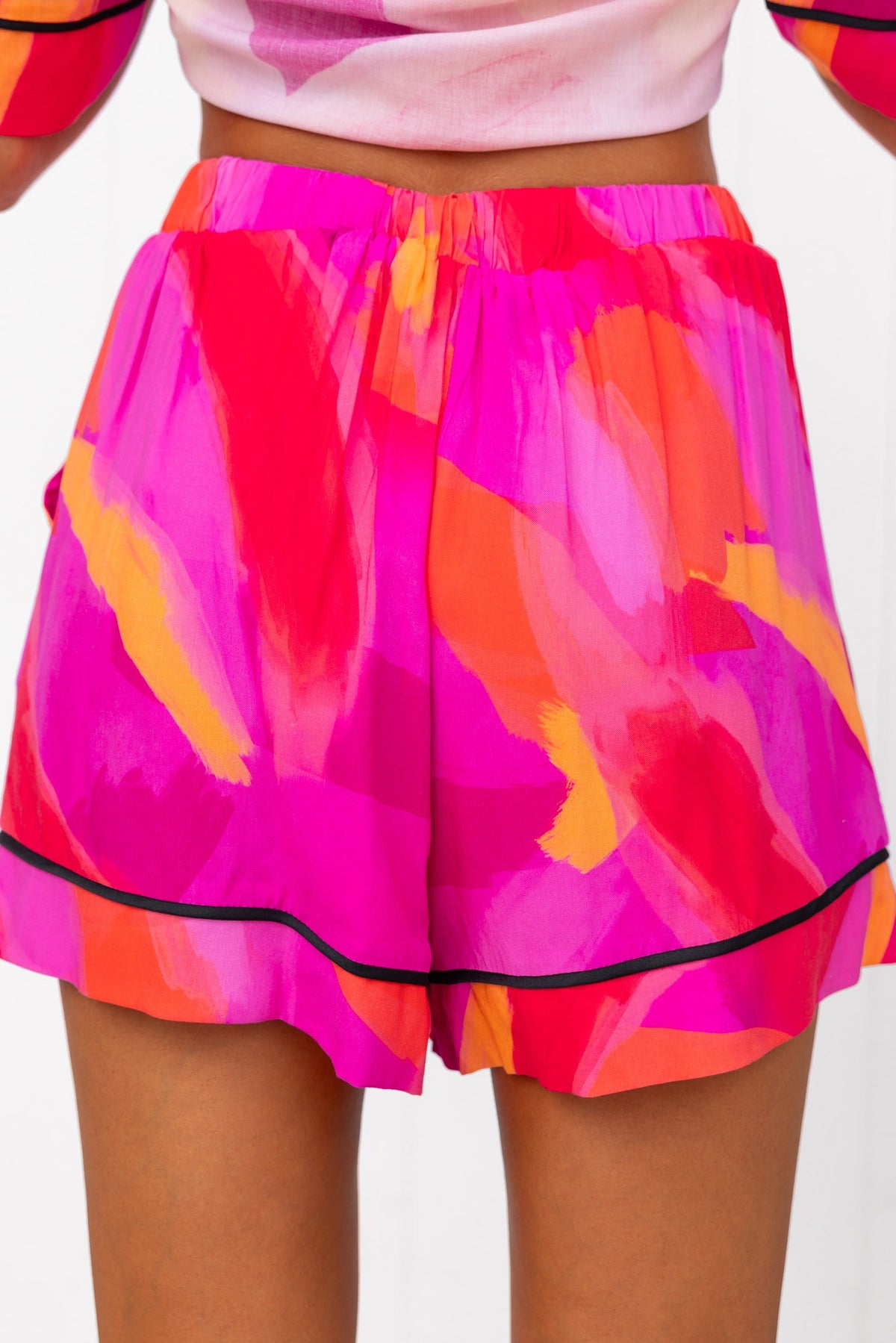 Colorful pink print shorts with a mid-high waist, elastic waistband, and pockets, perfect for casual summer wear.