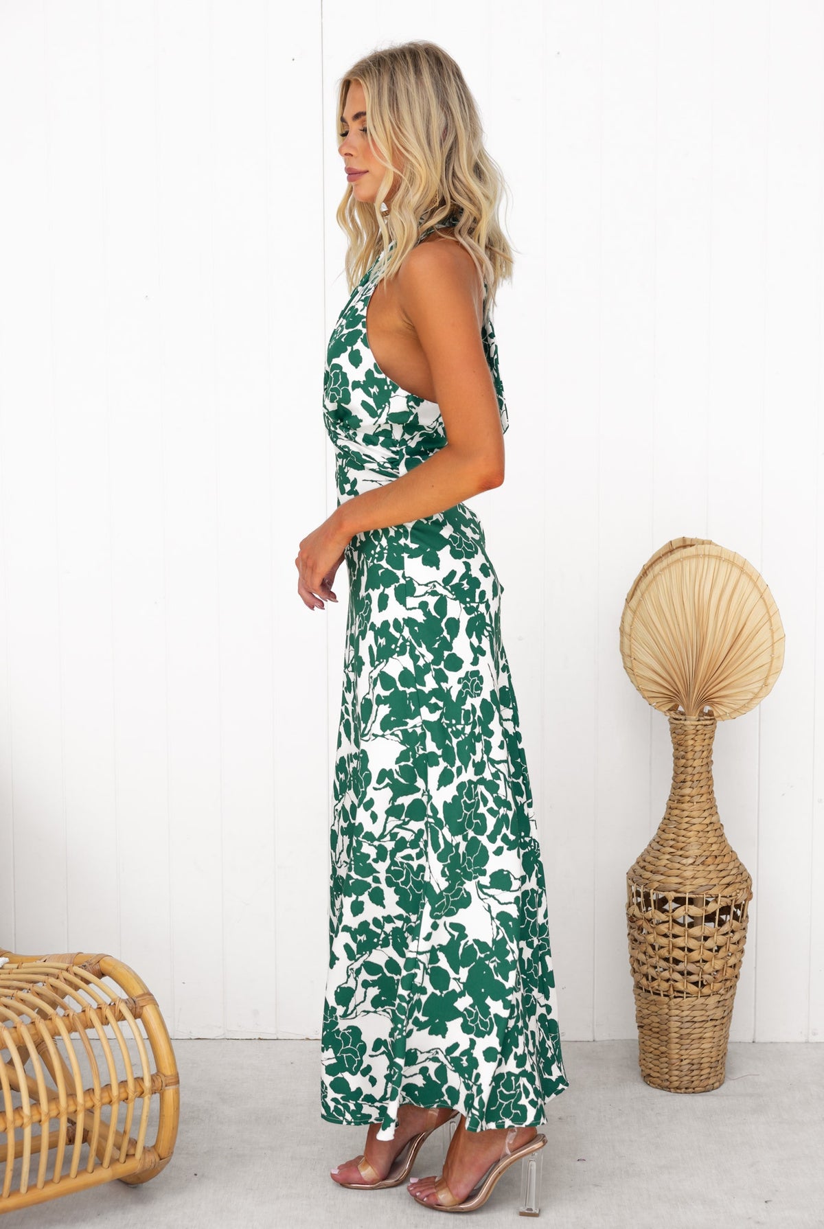 Model wearing the Renika maxi dress with a floral pattern, showcasing adjustable tie neckline and twist detail.