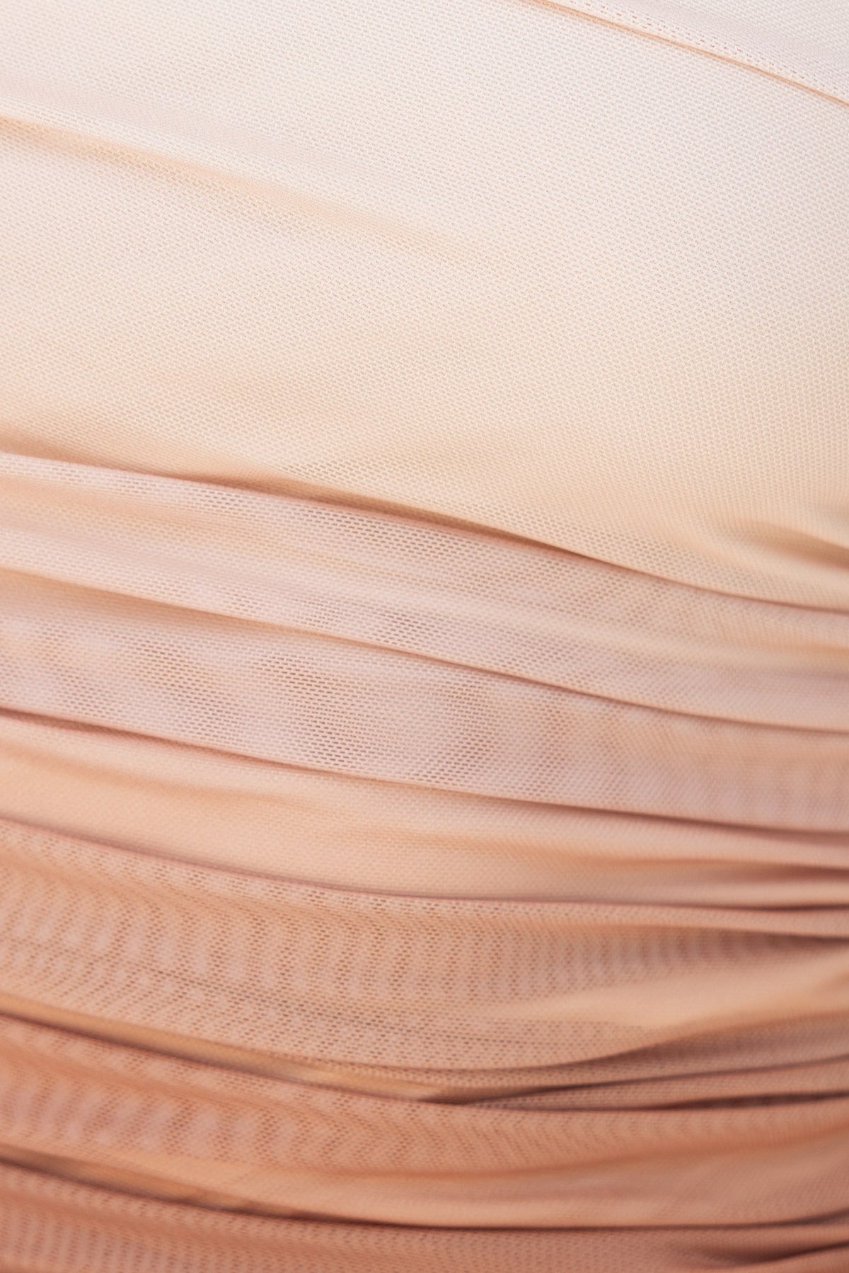 Close-up of ruching detail on a beige strapless top, showcasing soft, textured fabric and smooth finish.