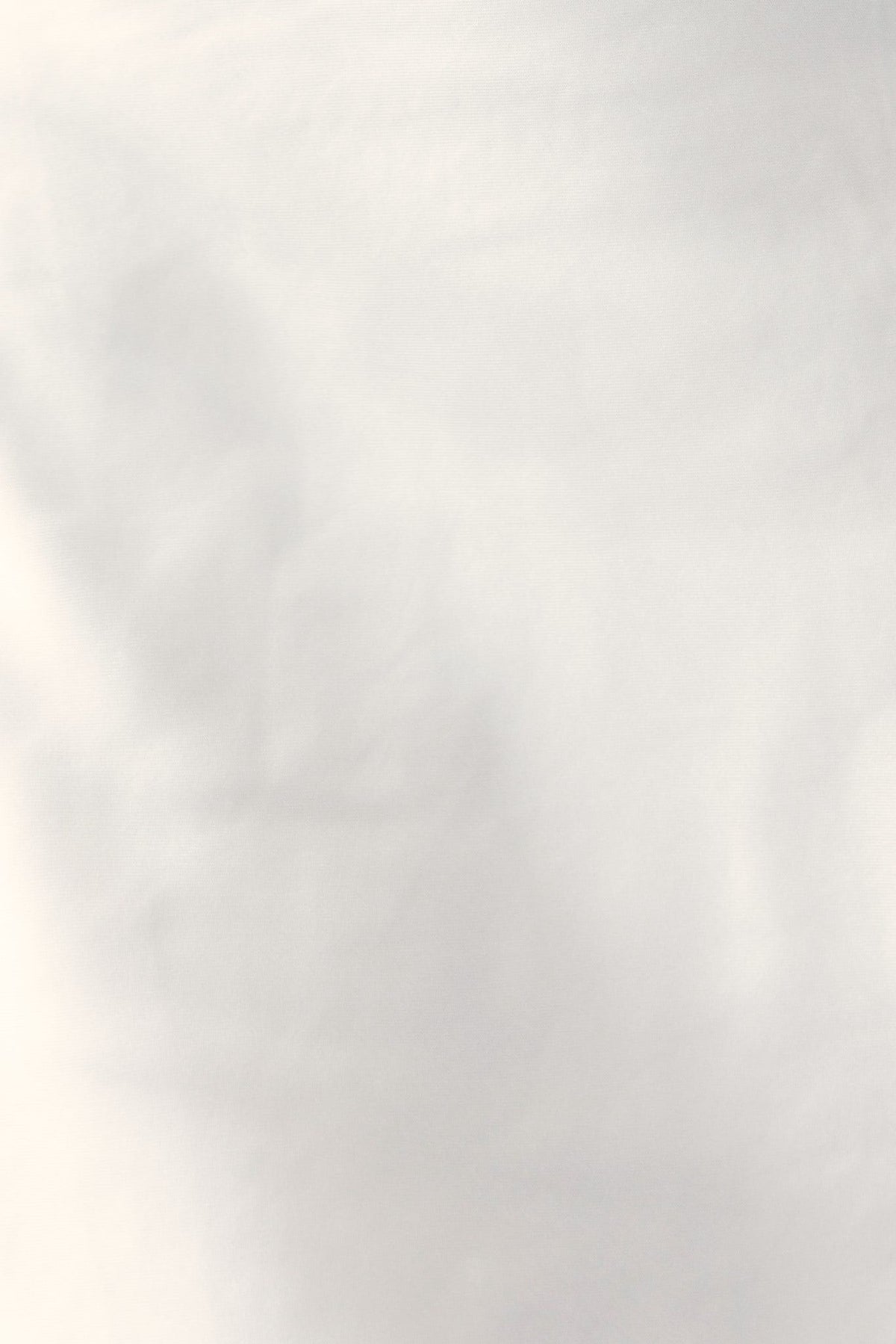 Close-up of soft satin fabric in ivory, showcasing a smooth texture, ideal for elegant dress designs.
