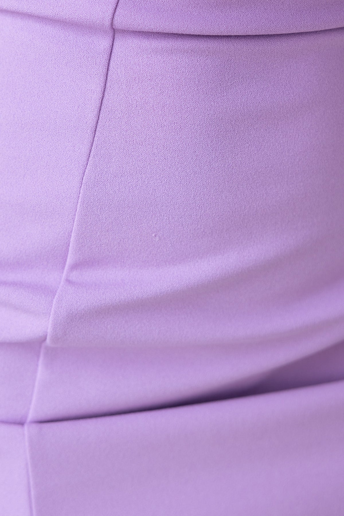 Close-up of Lila Dress in crepe fabric, showcasing smooth lavender texture and elegant design.