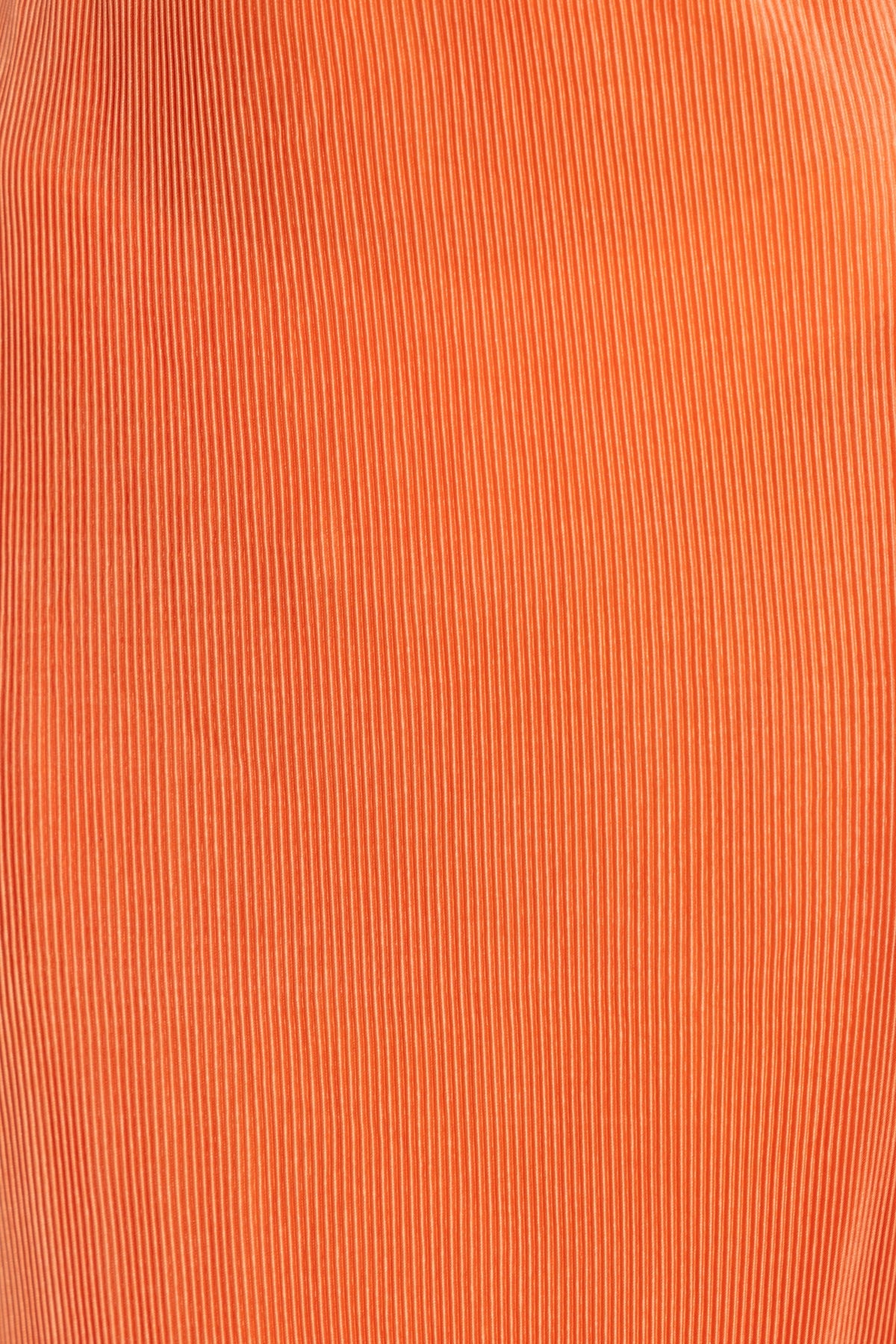 Close-up of orange accordion pleat fabric, showcasing texture and color for the Wondrous Maxi Skirt.
